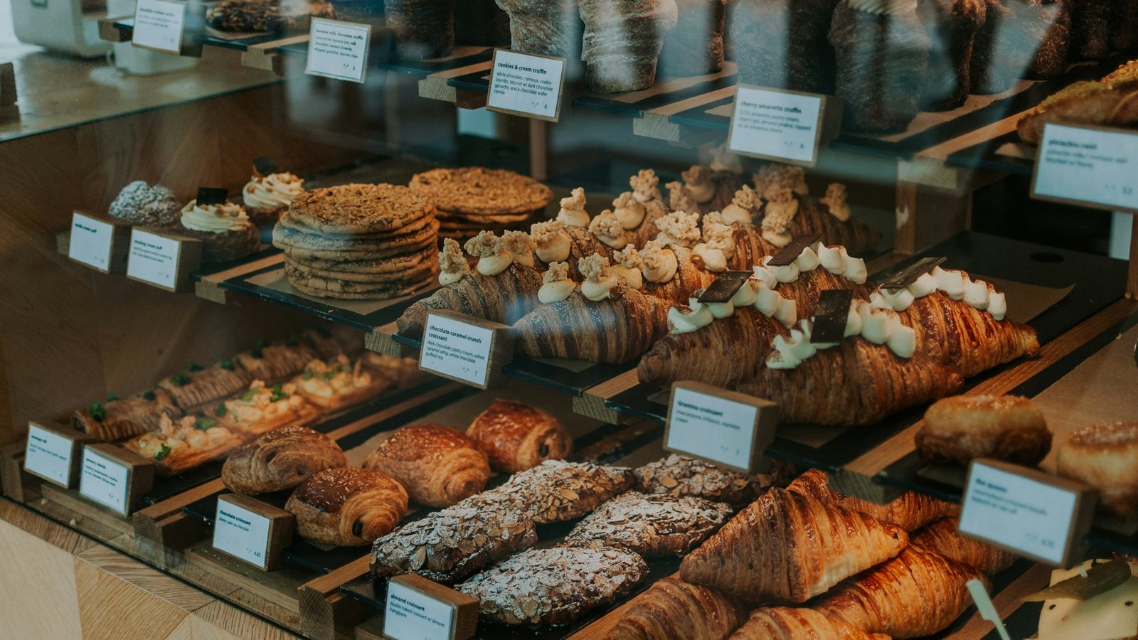 Vitrine de boulangerie garnie de croissants dorés et de viennoiseries sur des plateaux