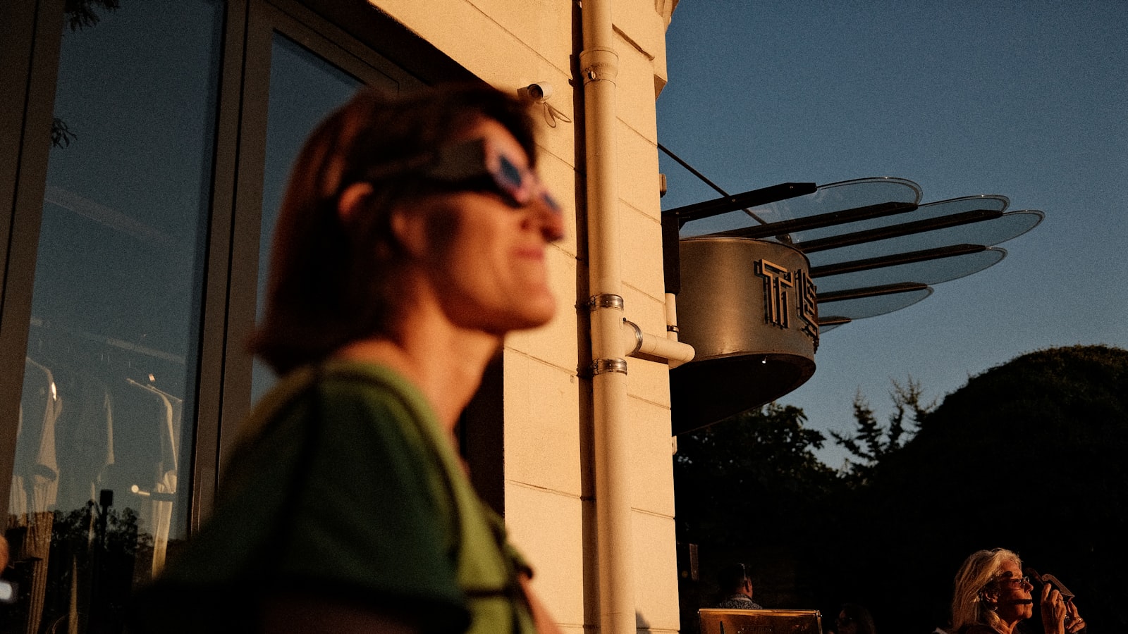 Femme portant des lunettes d'éclipse, tournée vers le ciel
