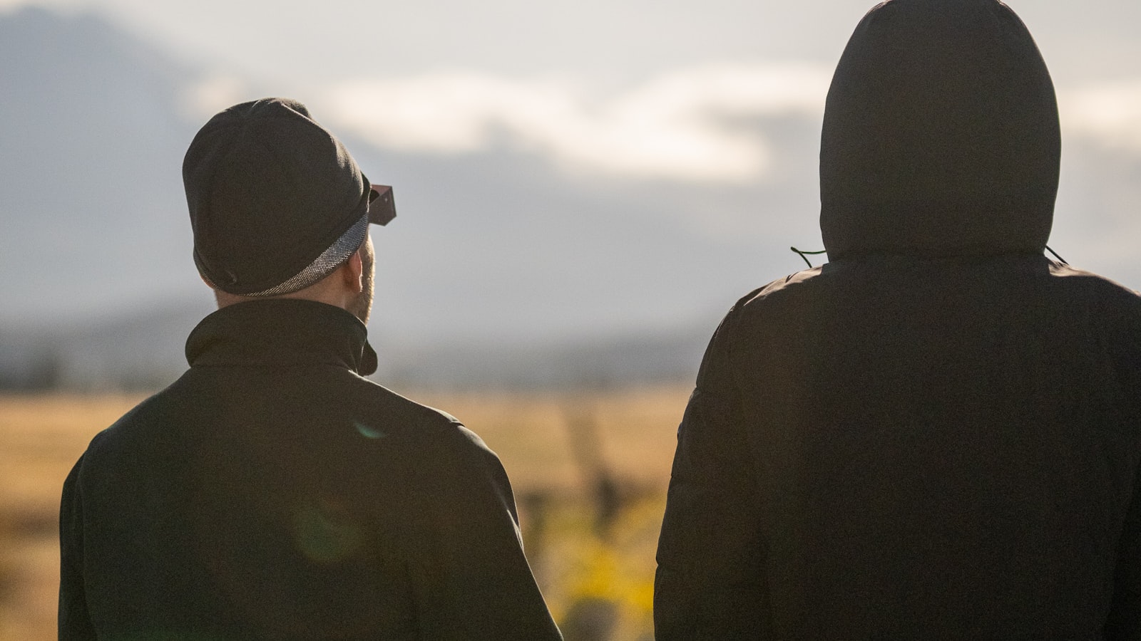 Deux observateurs de dos face à un ciel de fin de journée