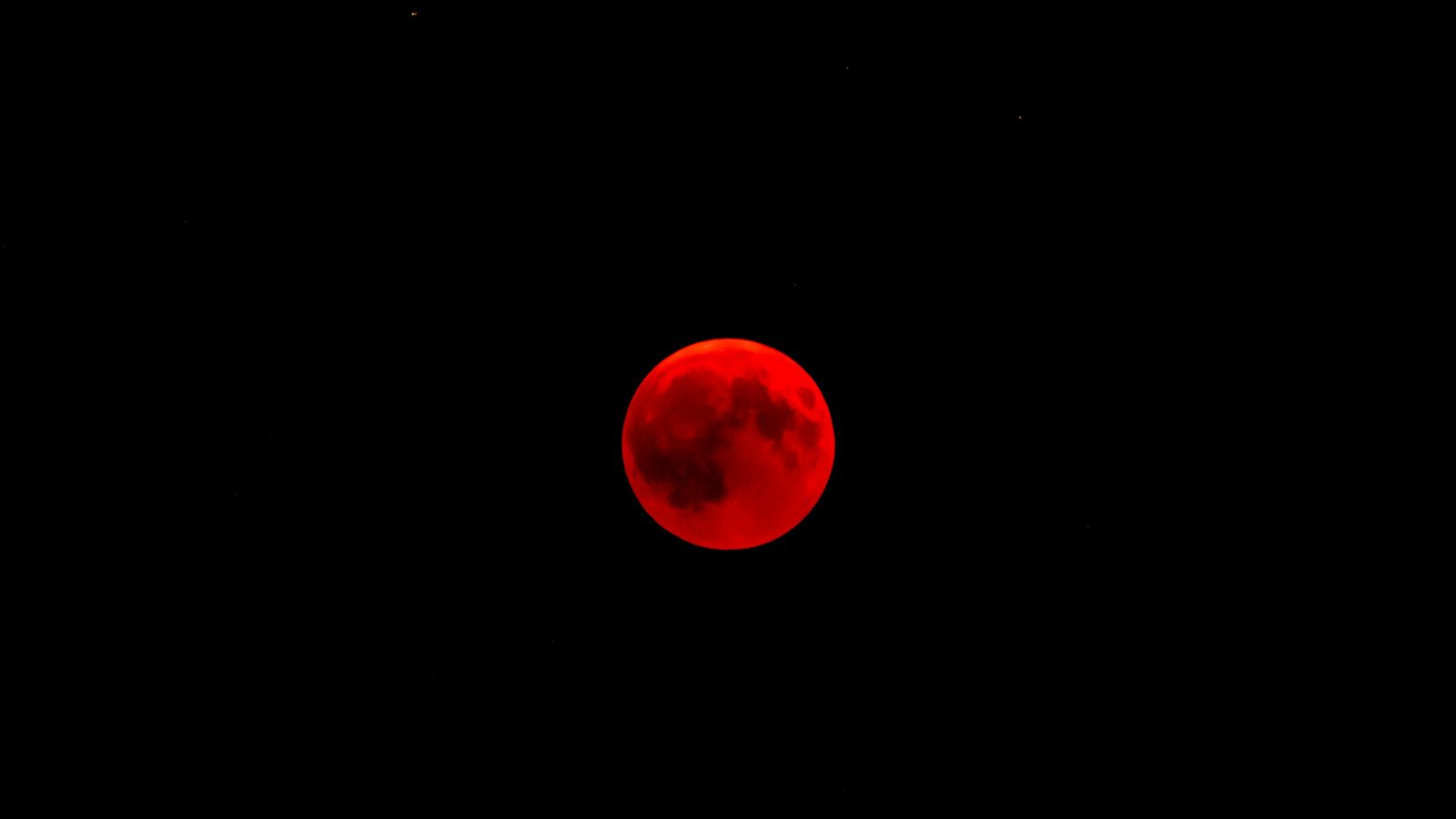 Lune presque entièrement plongée dans l'ombre de la Terre, avec un mince liseré resté éclairé sur son bord