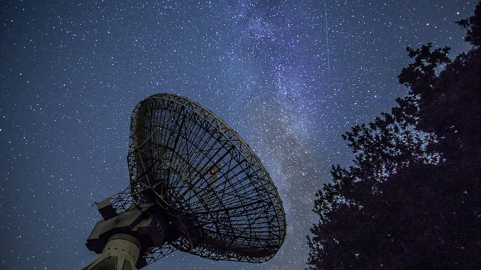 Paire de jumelles posée au premier plan devant la Lune basse sur l'horizon, en fin de nuit