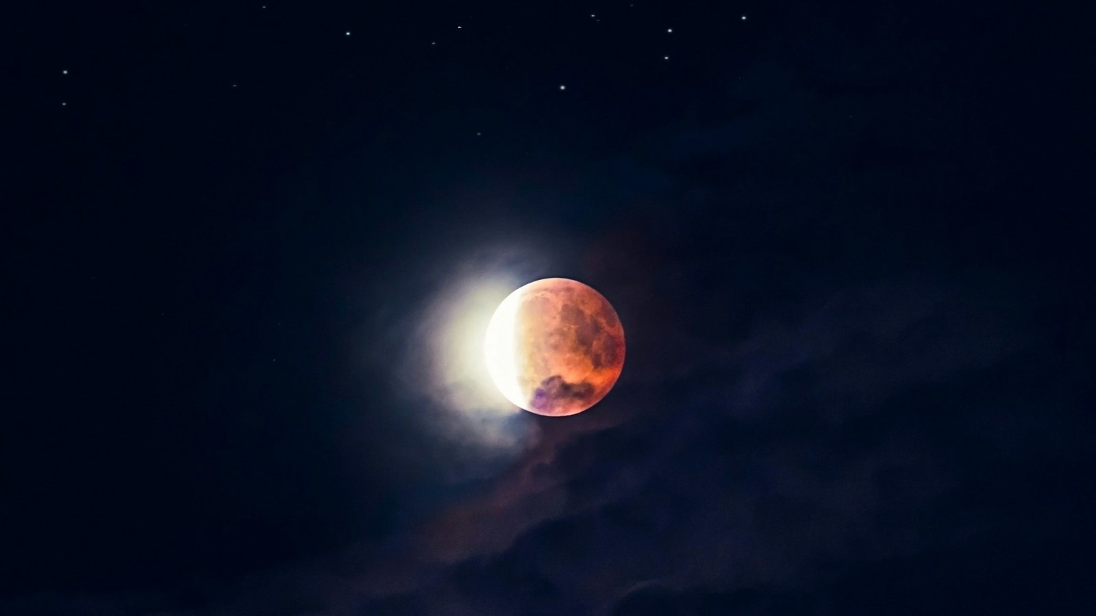 Lune partiellement plongée dans l'ombre de la Terre pendant une éclipse lunaire, observée à l'œil nu dans un ciel sombre