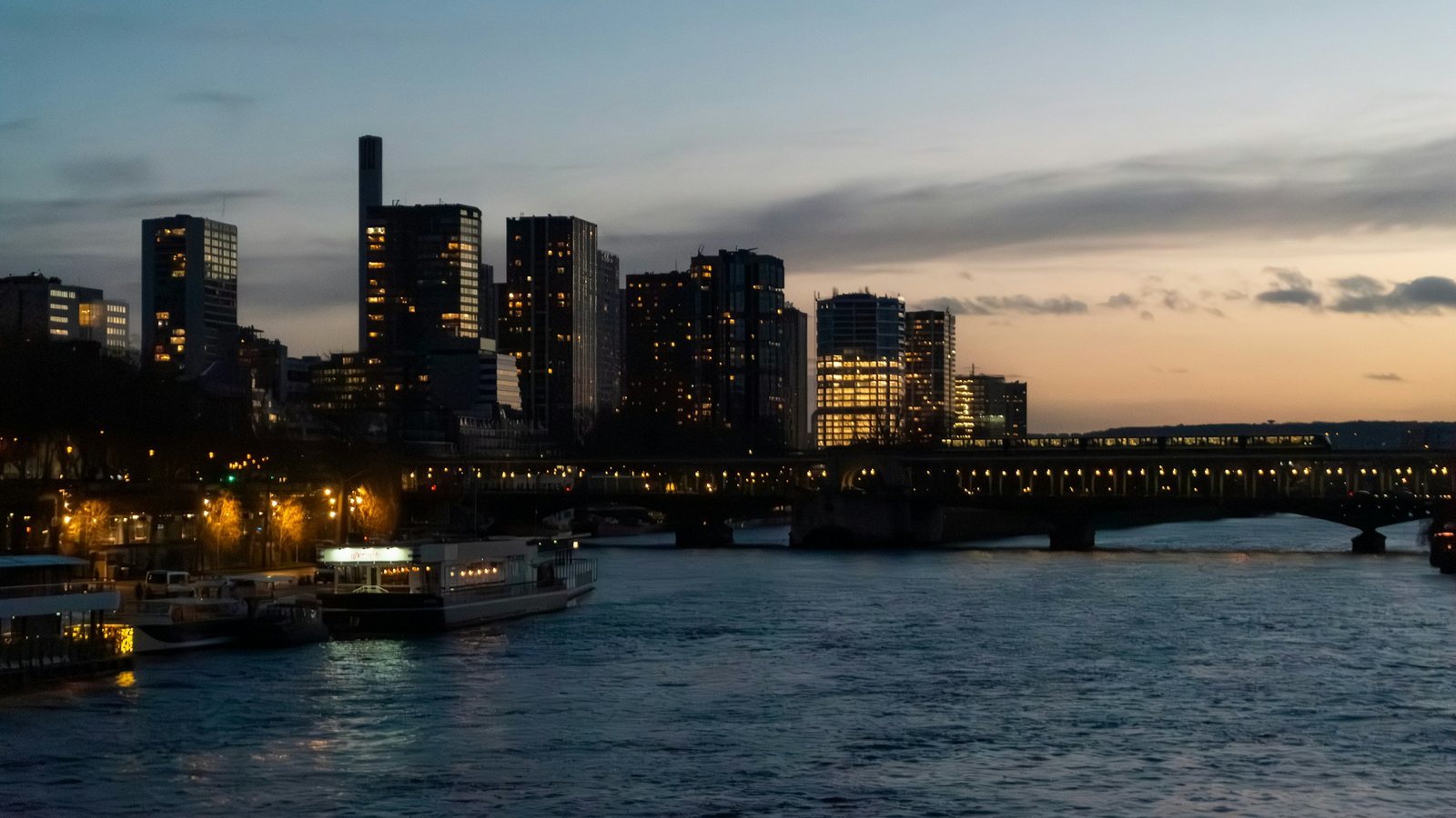 Lune partiellement mordue par l'ombre de la Terre, basse dans un ciel sombre au-dessus d'une ligne d'horizon dégagée
