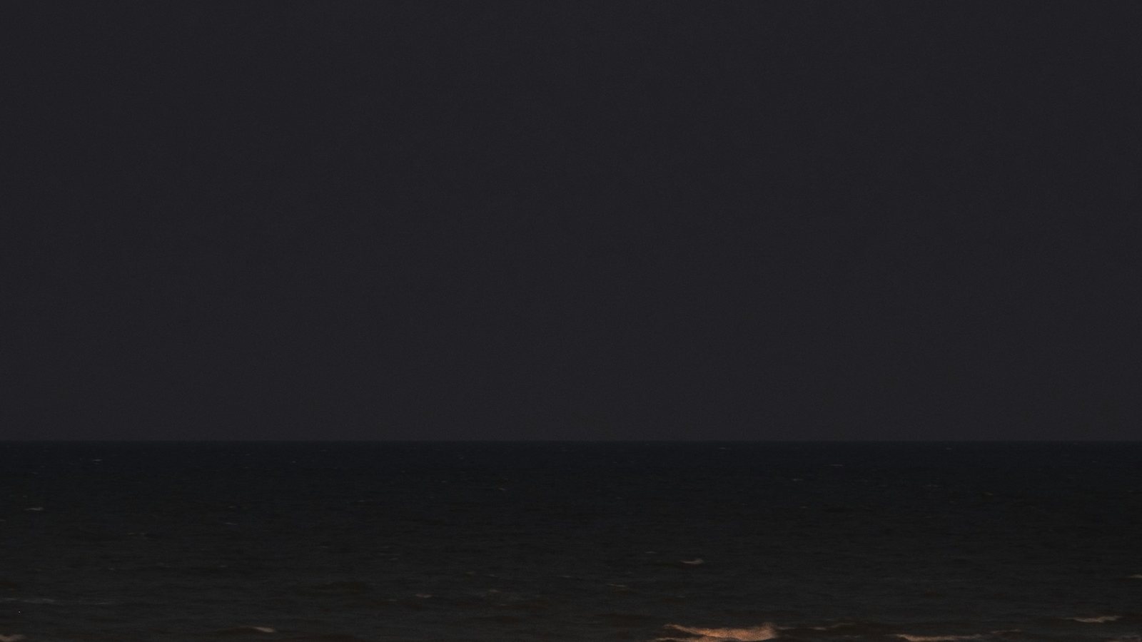 Lune basse au-dessus d'un horizon dégagé dans un ciel de fin de nuit