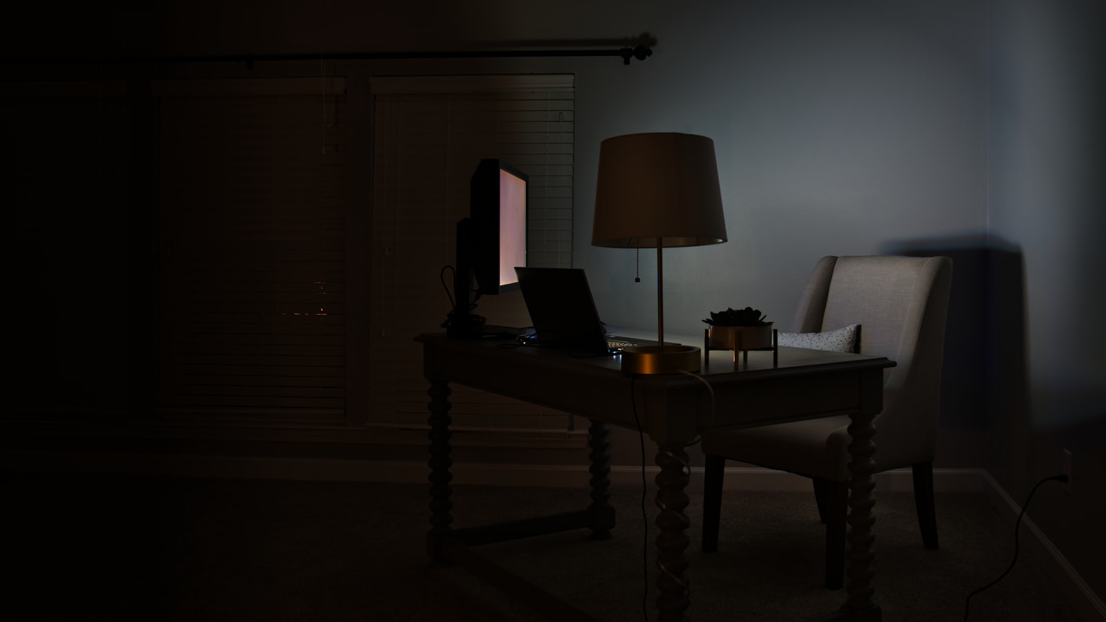 Chambre sombre éclairée par une lampe
