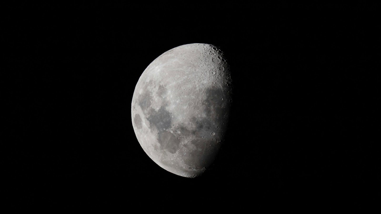 Gros plan d'une Lune gibbeuse sur fond de ciel entièrement noir, cratères et mers lunaires nettement dessinés