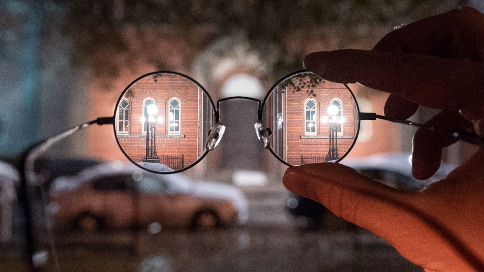 Paire de lunettes de vue tenue devant une rue