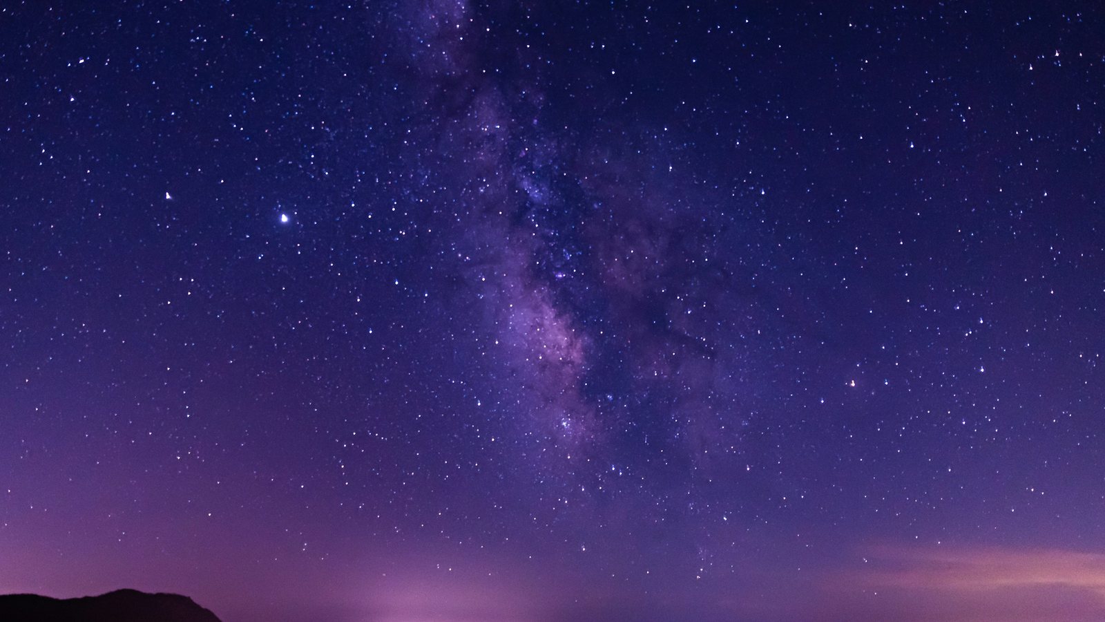 La Voie lactée violette déployée au-dessus d'une baie et de ses lumières lointaines, nuit du samedi 10 octobre 2026