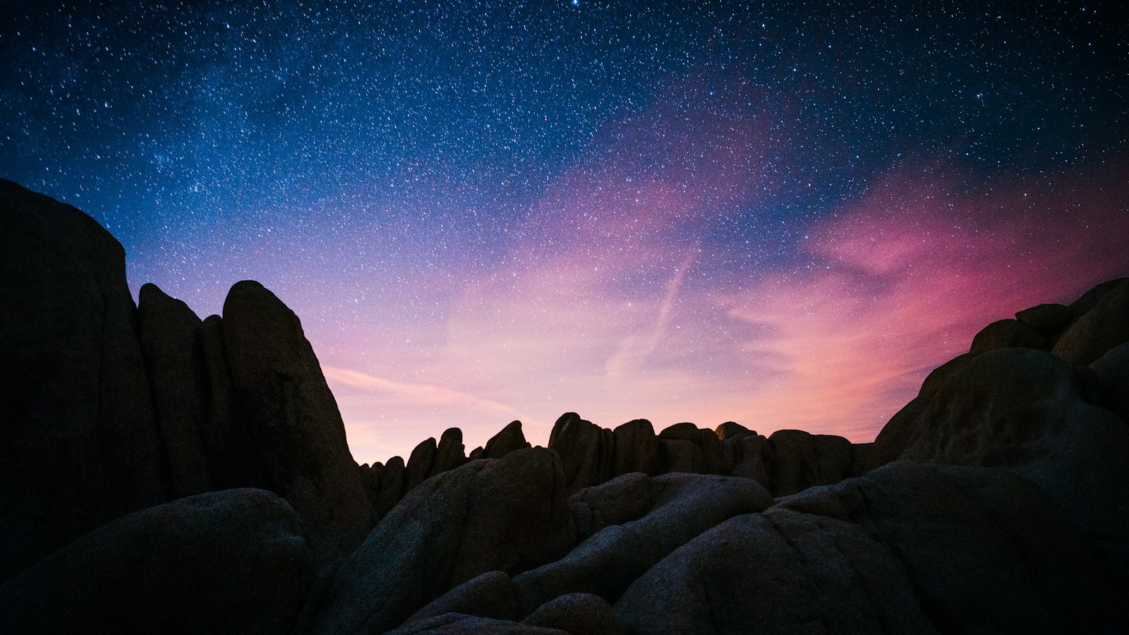 Un ciel étoilé teinté de rose au-dessus de rochers sombres, aube du lundi 28 septembre 2026