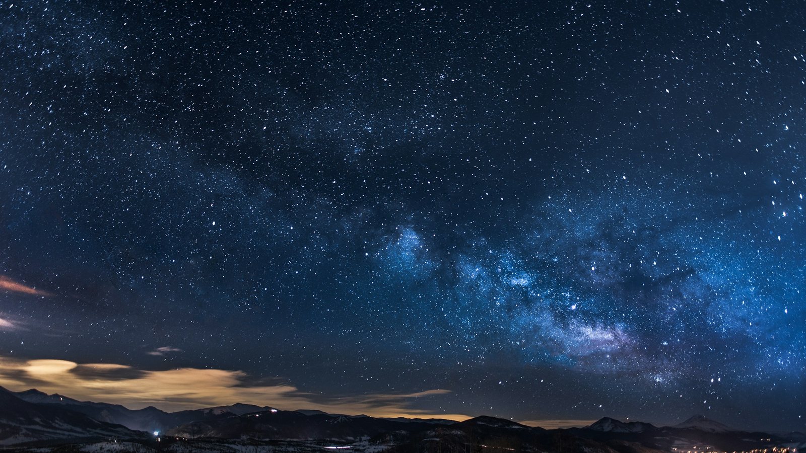 La Voie lactée déployée au-dessus d'une vallée enneigée piquetée de lumières, nuit du lundi 5 octobre 2026