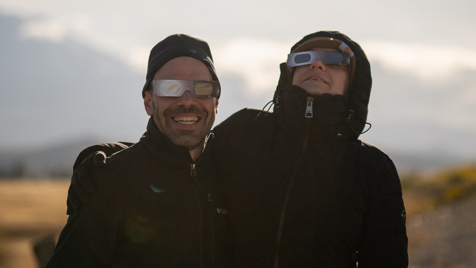 Deux personnes portant des lunettes d'éclipse en carton
