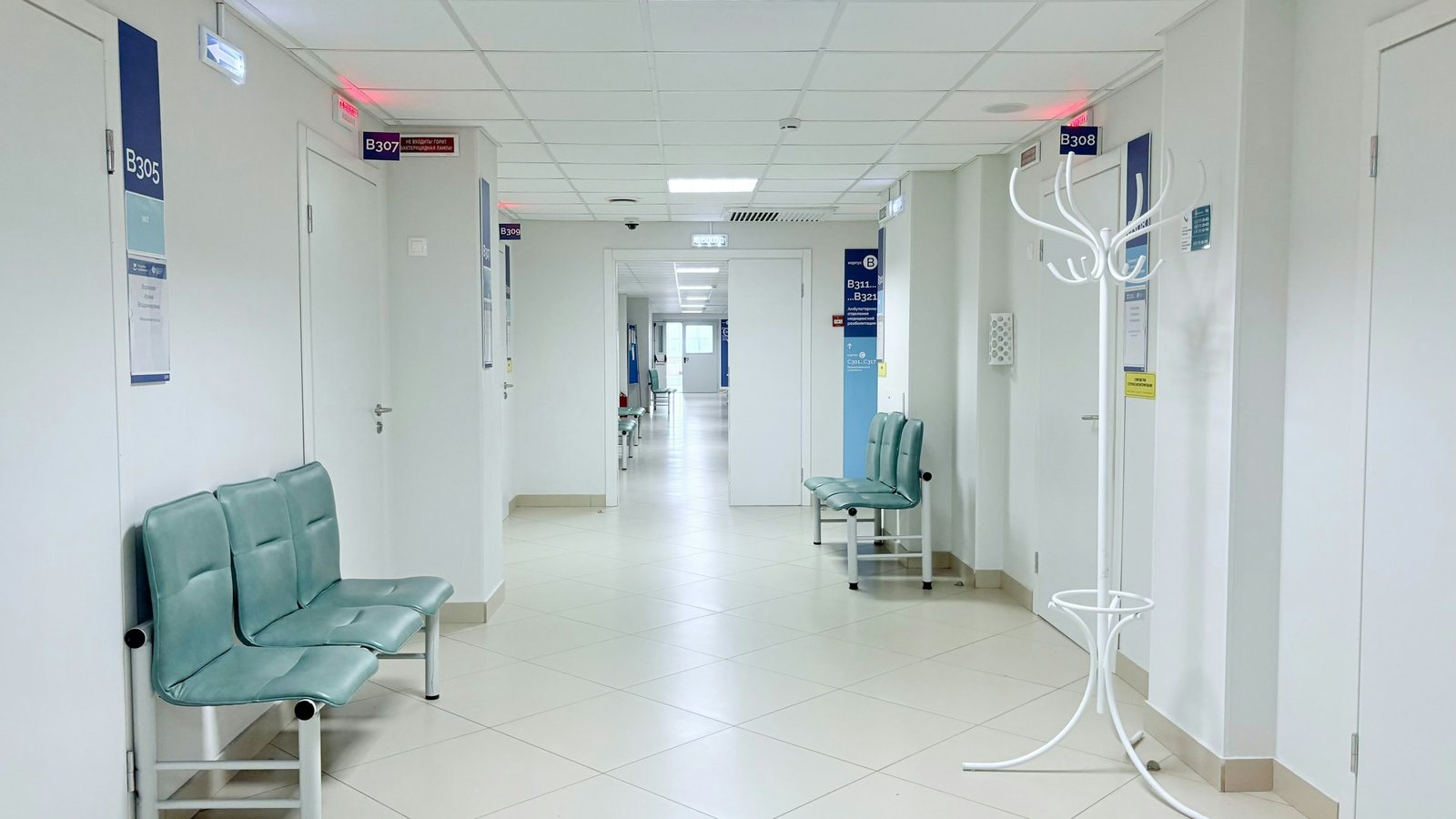 Un couloir d'hôpital vide bordé de bancs