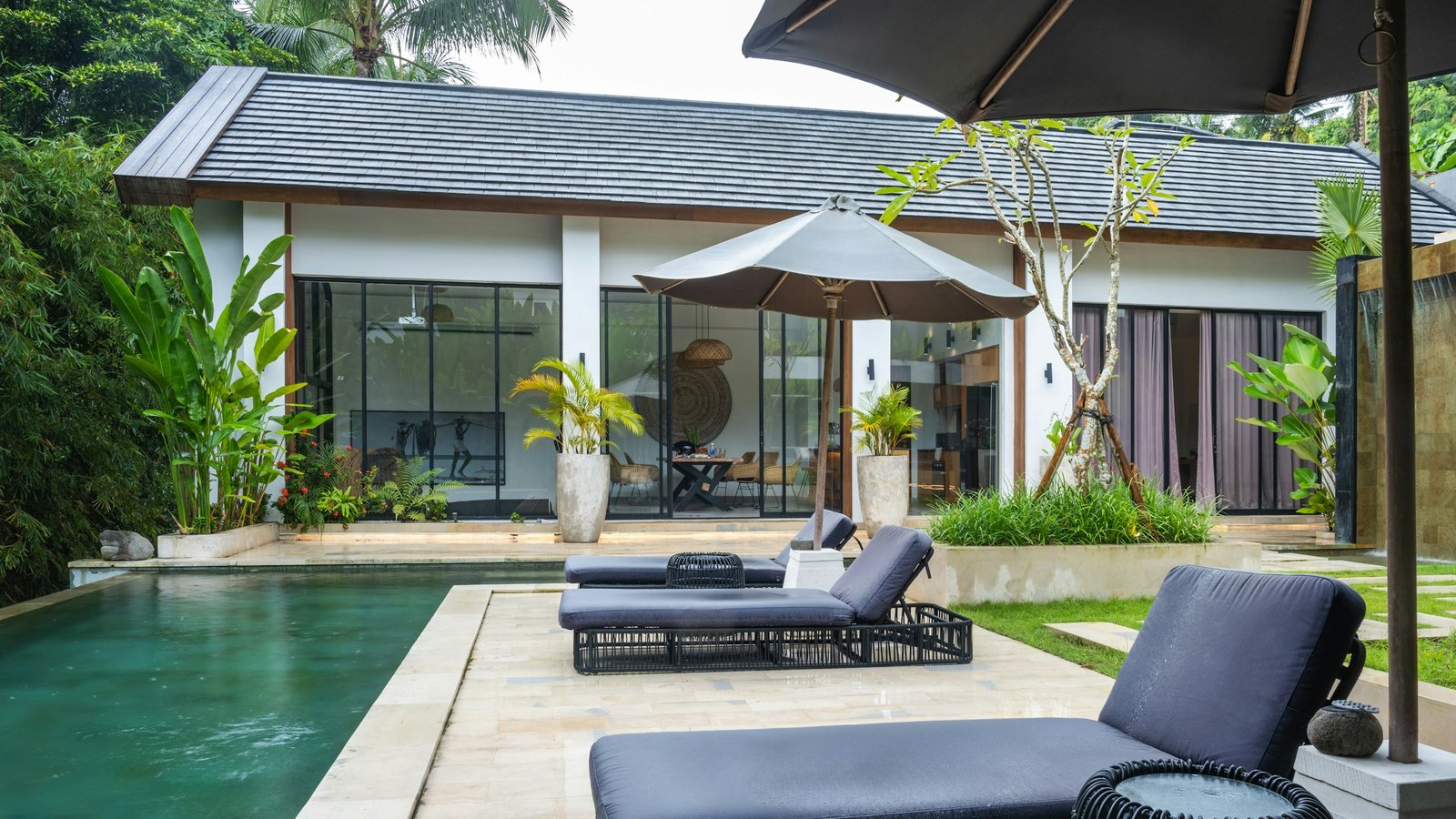 Une piscine bordée de chaises longues et d'un parasol