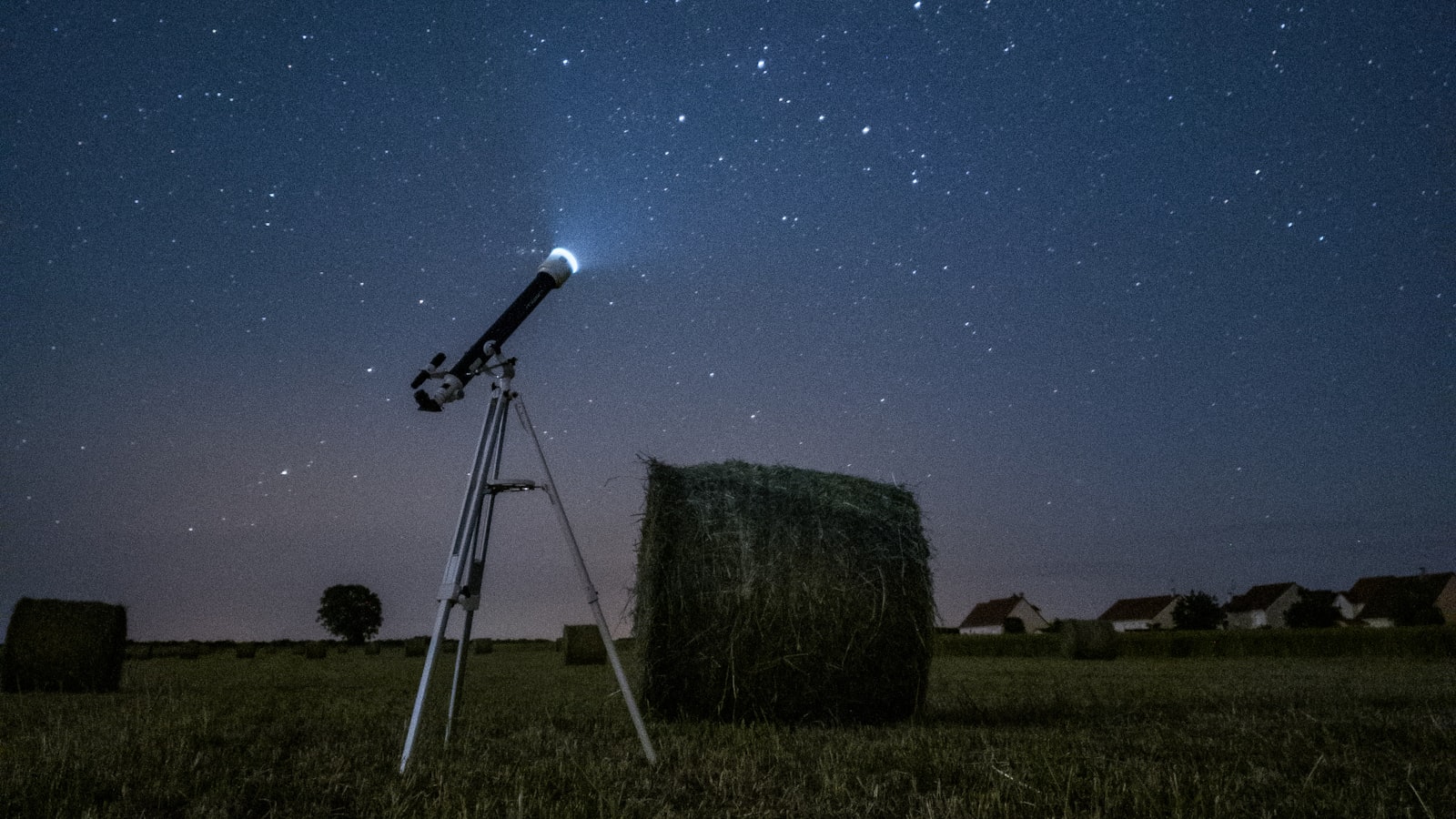 Fragment de météorite rocheuse à la surface sombre et croûtée, posé sur un fond neutre