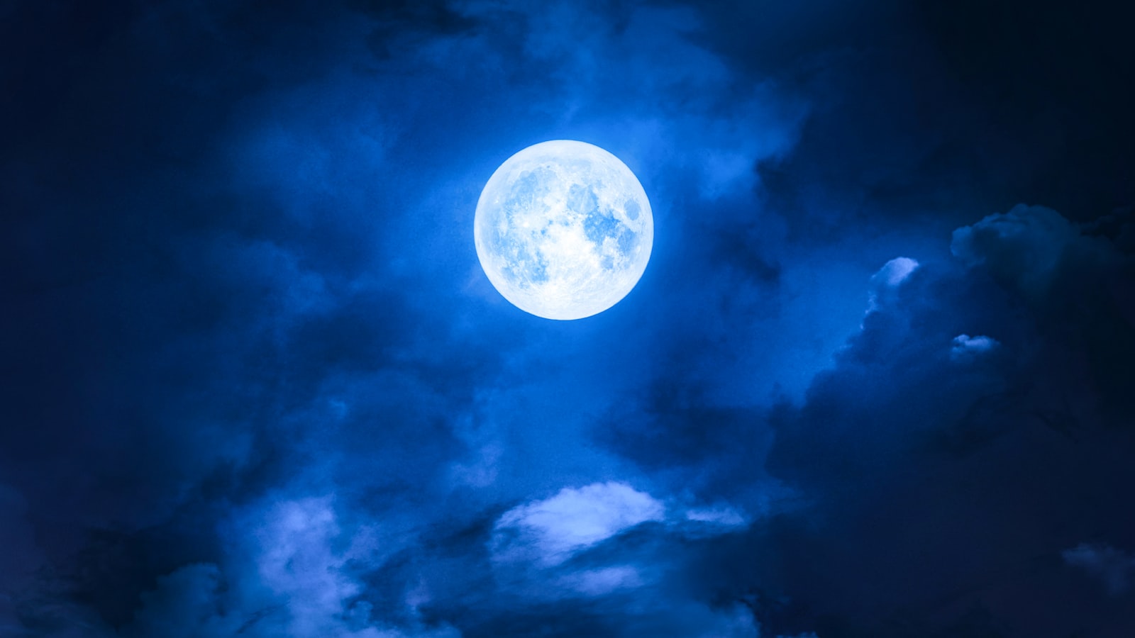 Lune dans un ciel nuageux bleu nuit