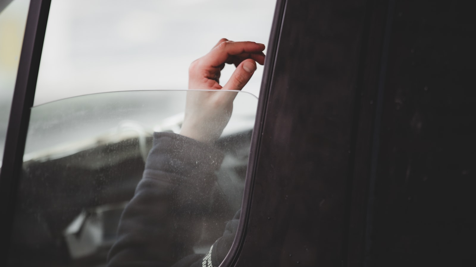 Main levée à la vitre d'une voiture en signe de remerciement