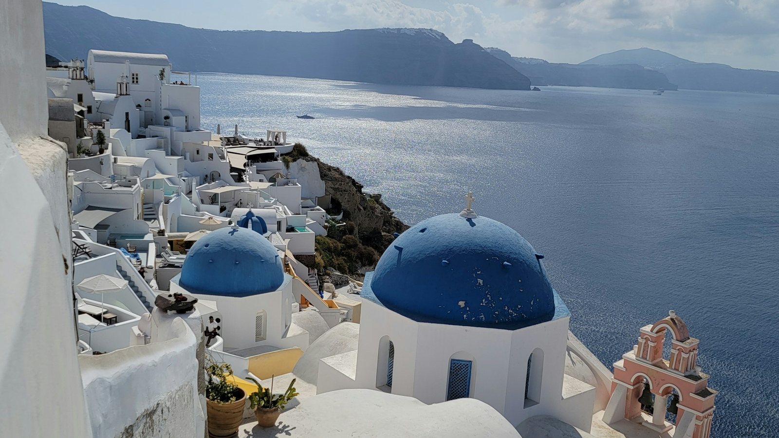 Maisons blanches d'un village grec surplombant la mer Égée sous le soleil