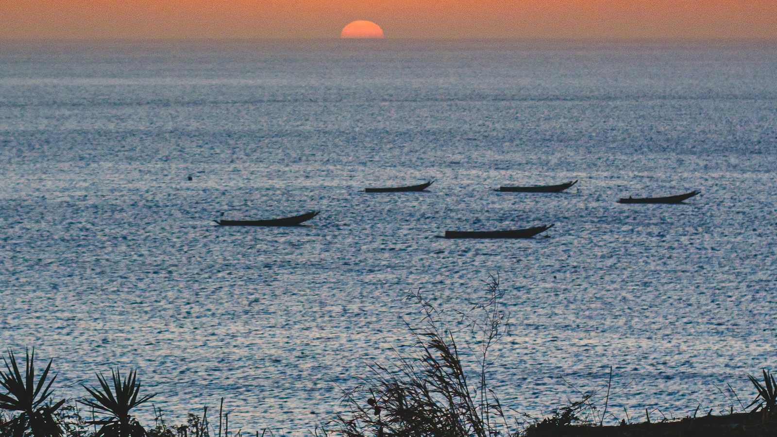 La côte sénégalaise et ses pirogues colorées sous le soleil, avec l'océan Atlantique en arrière-plan