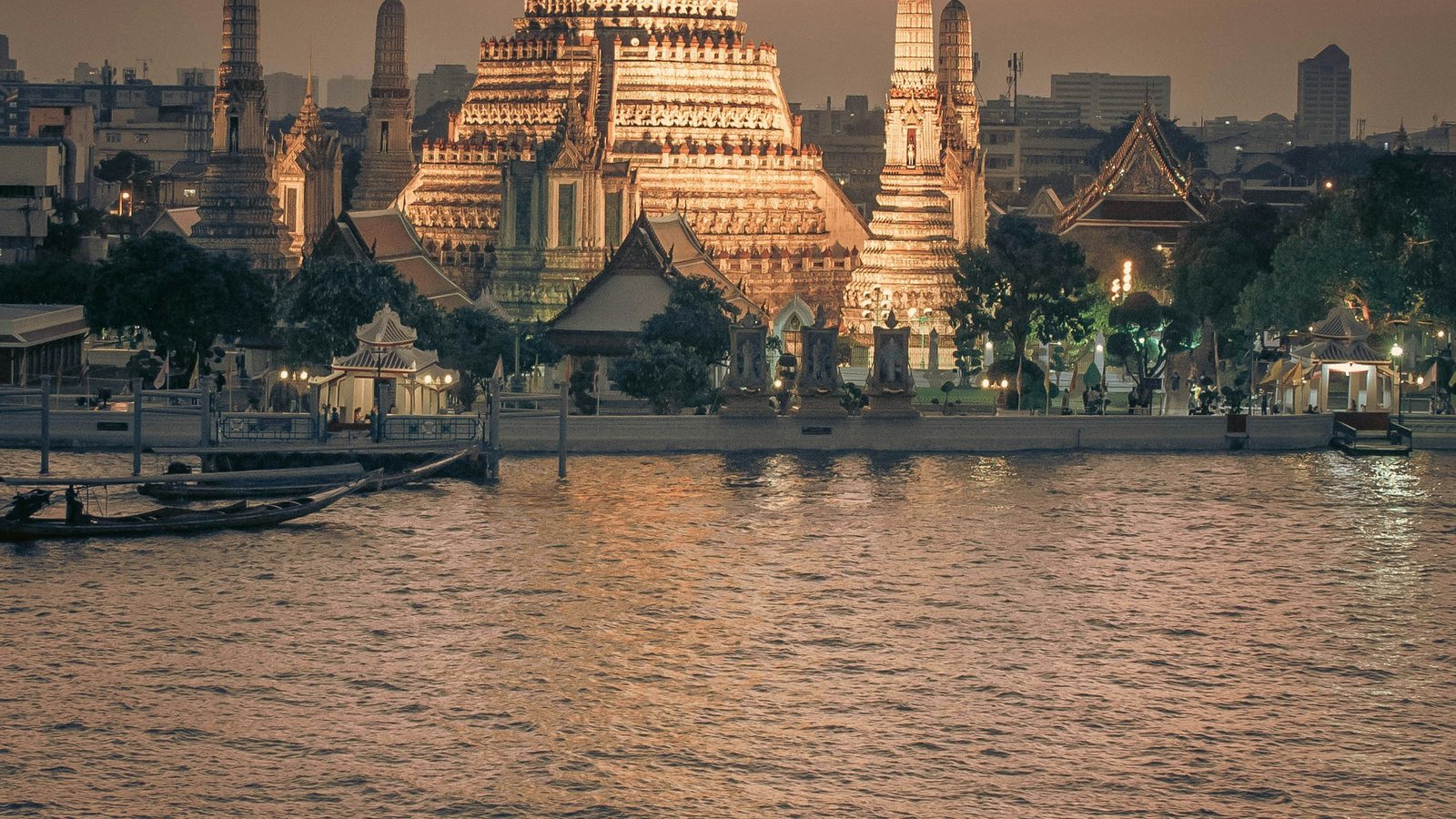 Un bateau sur le fleuve devant les tours de Bangkok