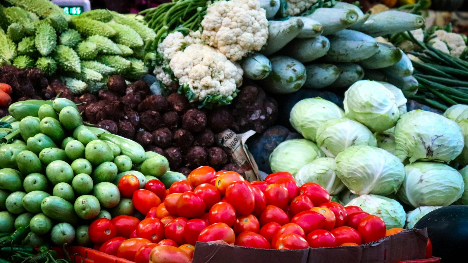 Un étal de légumes dans la pénombre d'un marché