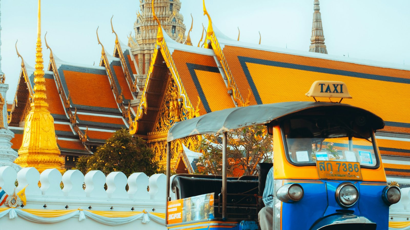 Un tuk-tuk bleu et jaune dans la circulation