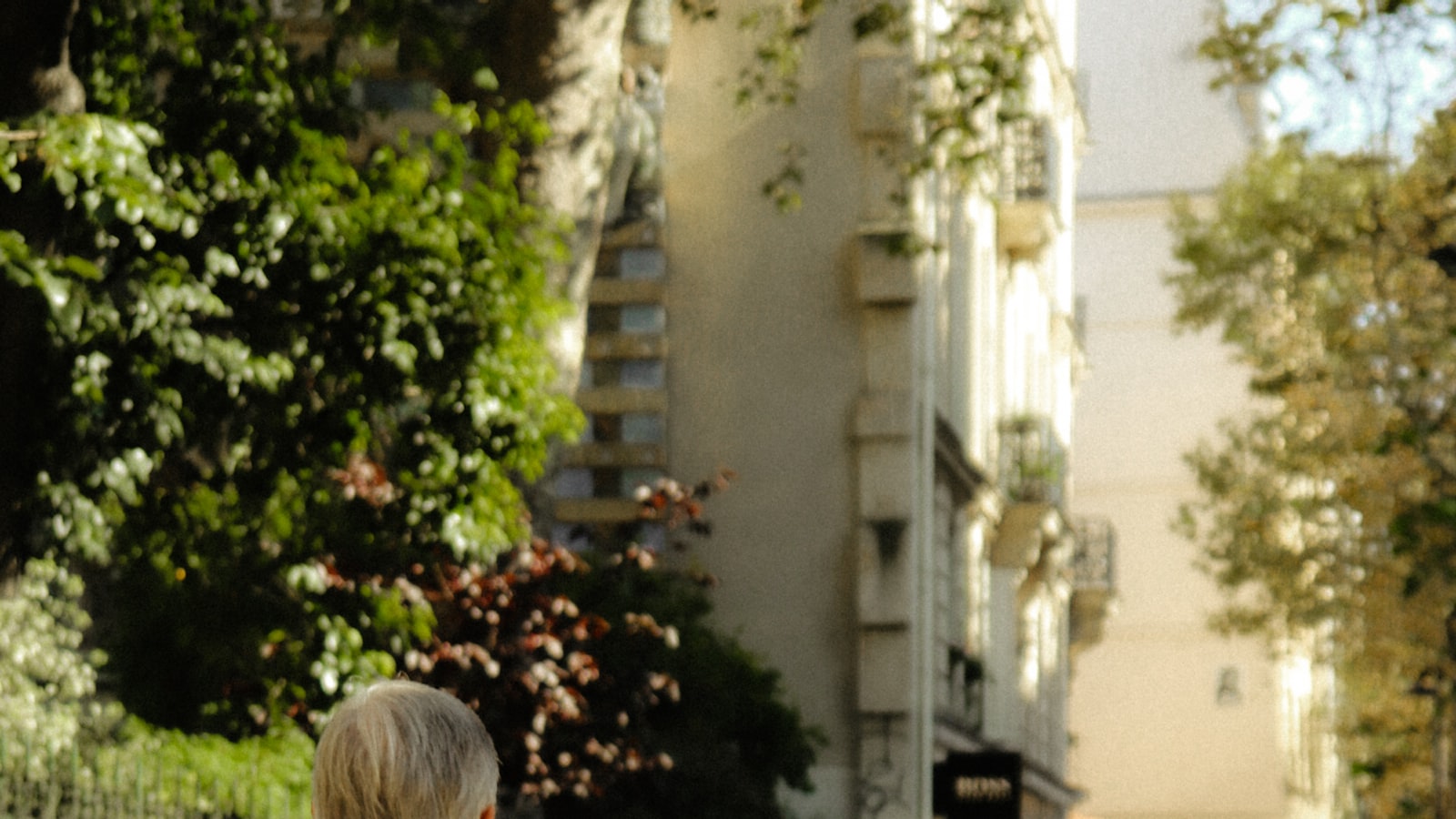 Personne assise près d'une fenêtre, le menton posé sur la main, absorbée dans ses pensées