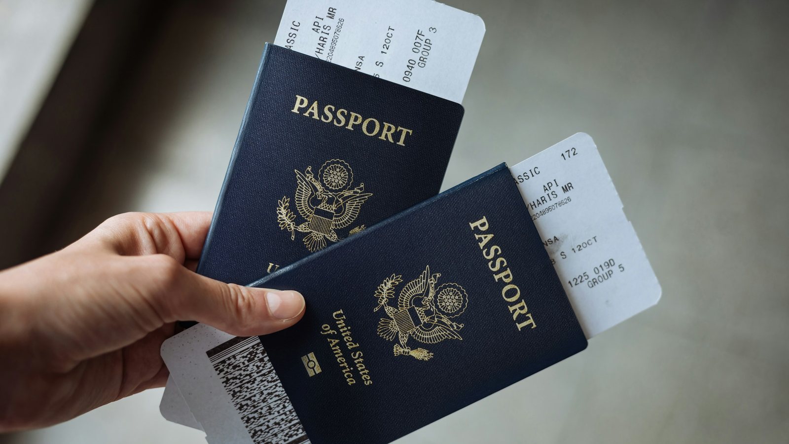 Deux passeports tenus en main avec leurs cartes